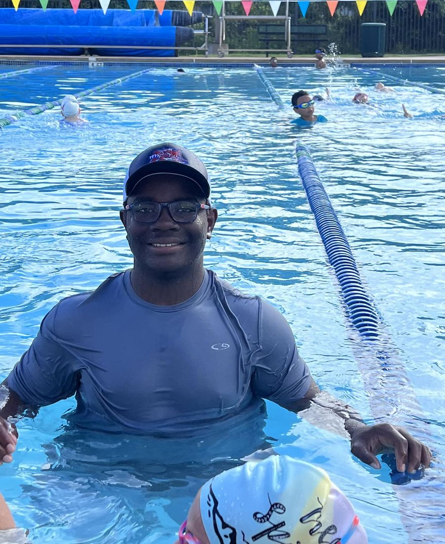 Xavier coaching a young swimmer in the pool